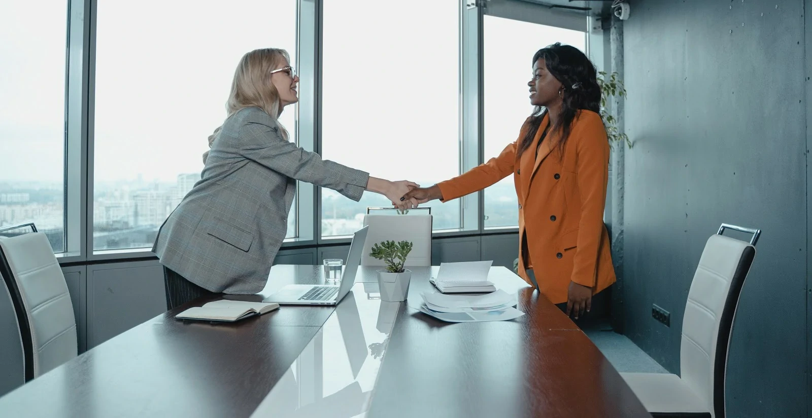   Deux femmes dans un bureau se serrent la main.